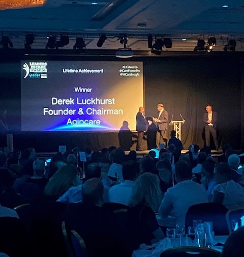 Lifetime achievement winner Derek Luckhurst on stage receiving his trophy at the leaders in care awards